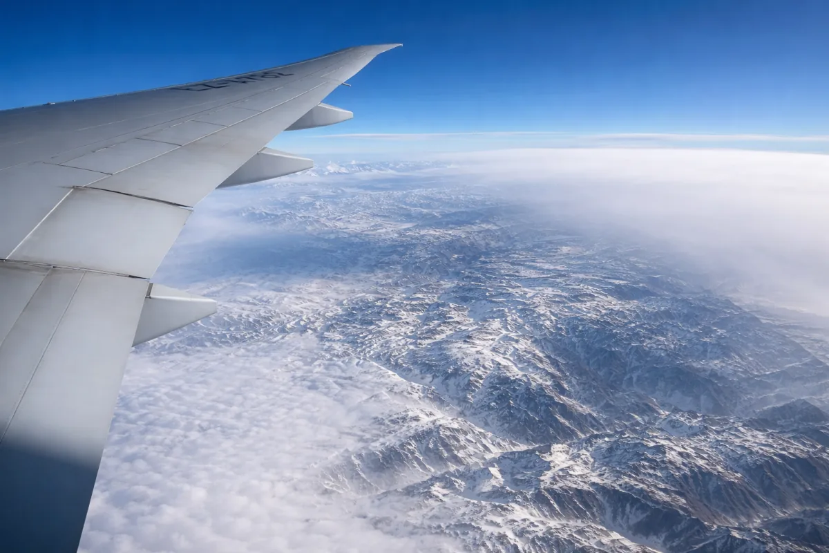 View across a mountain range from an aircraft window